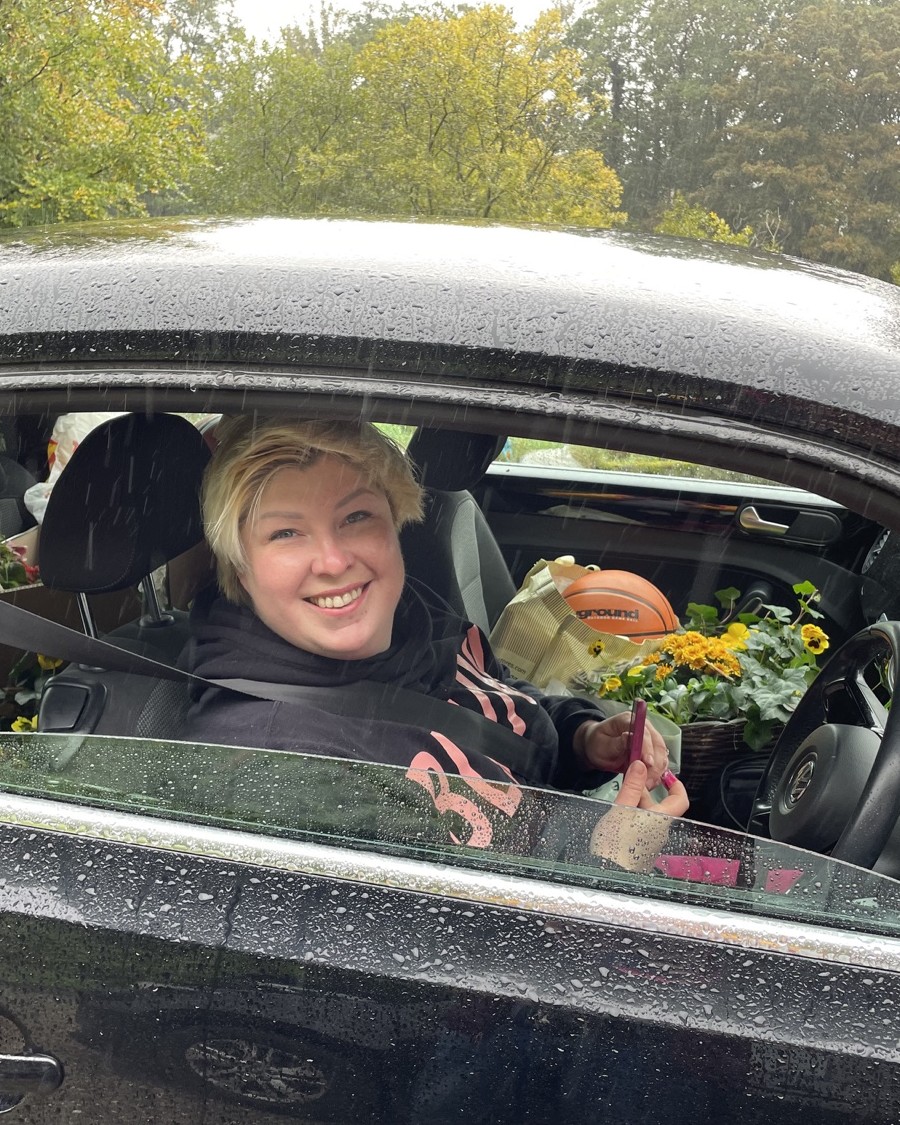 Anya Tavlinska smiling inside a car on a rainy day in Ireland.